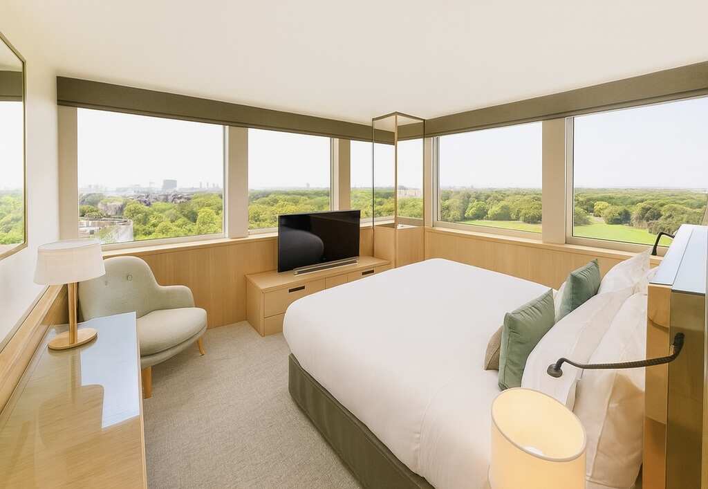 غرفة فندقية حديثة بإطلالة بانورامية على هايد بارك في لندن مع تصميم داخلي هادئ وأثاث مريح